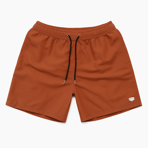 Flatlay of terracotta swim shorts with drawstring waist, displayed on a white background.